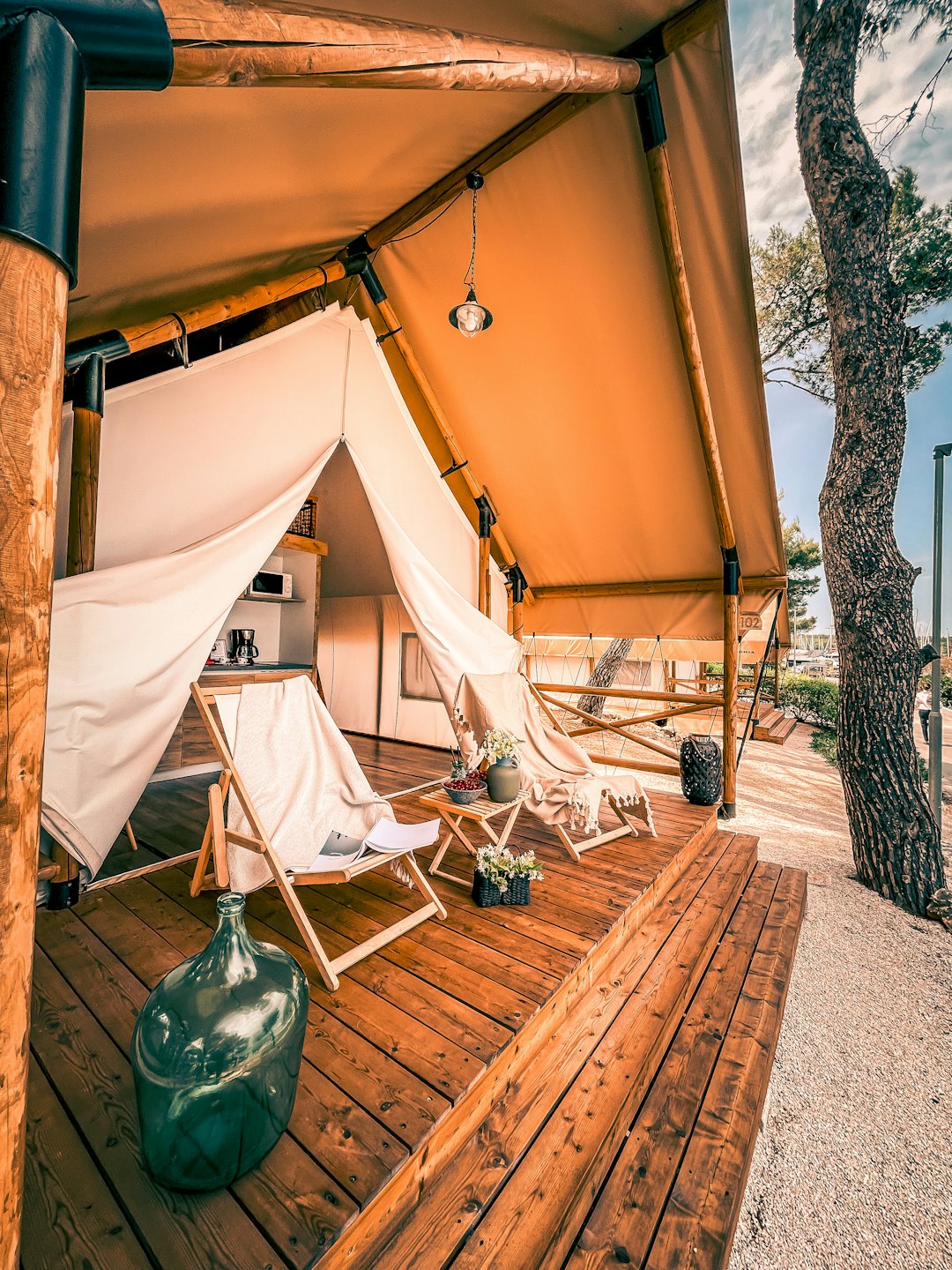 Interno spazioso di una tenda glamping con cucina e terrazza in legno.
